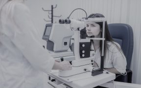 młoda kobieta badająca wzrok na specjalistycznym urządzeniu u okulisty