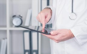 doktor dotykający palcem wskazującym tablet