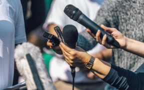 dziennikarze z mikrofonami i dyktafonami przeprowadzający wywiad