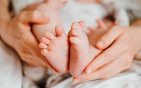ręce matki trzymjące noworodka