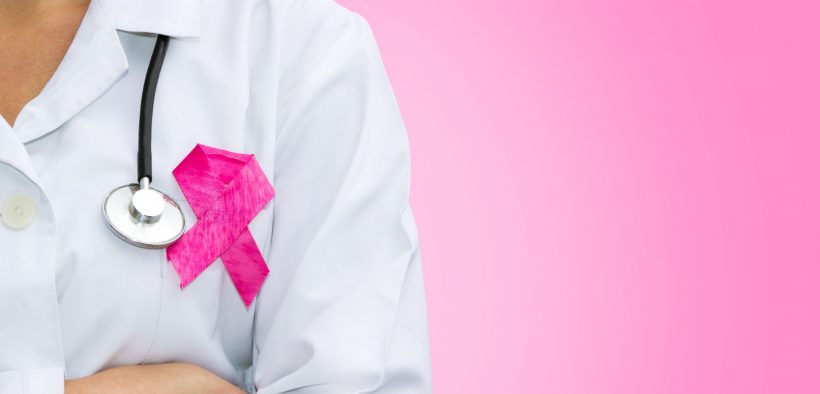 lekarka w kitlu ze stetoskopem na szyi i różową wstążką na piersi